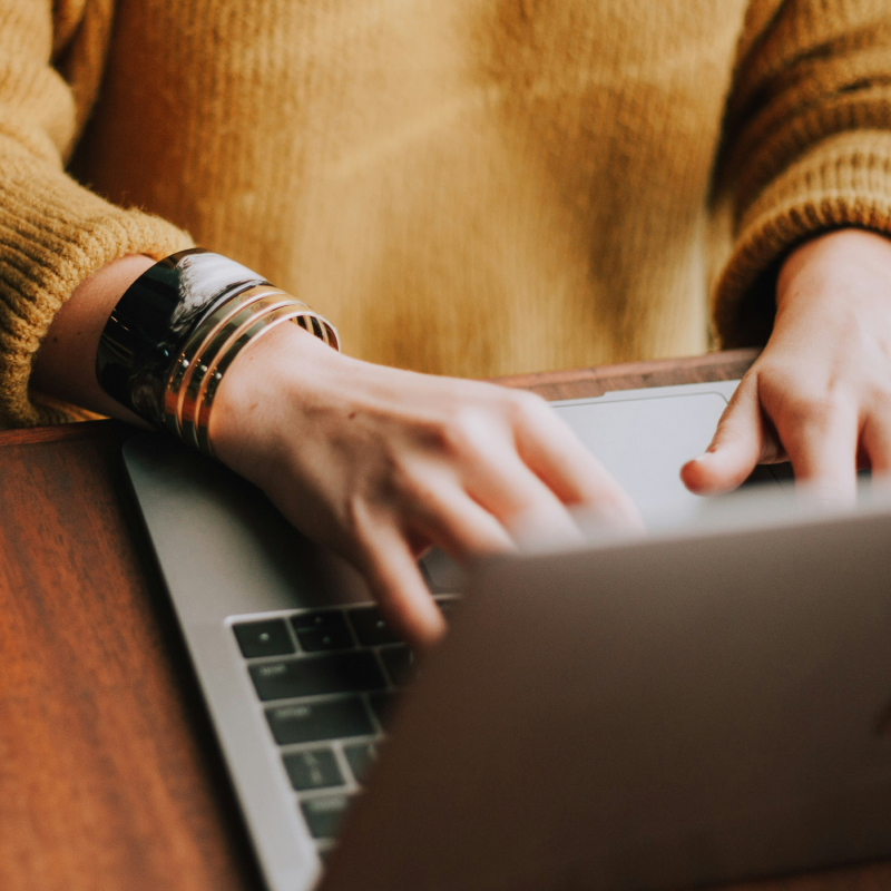 Persons hands shown typing on a laptop